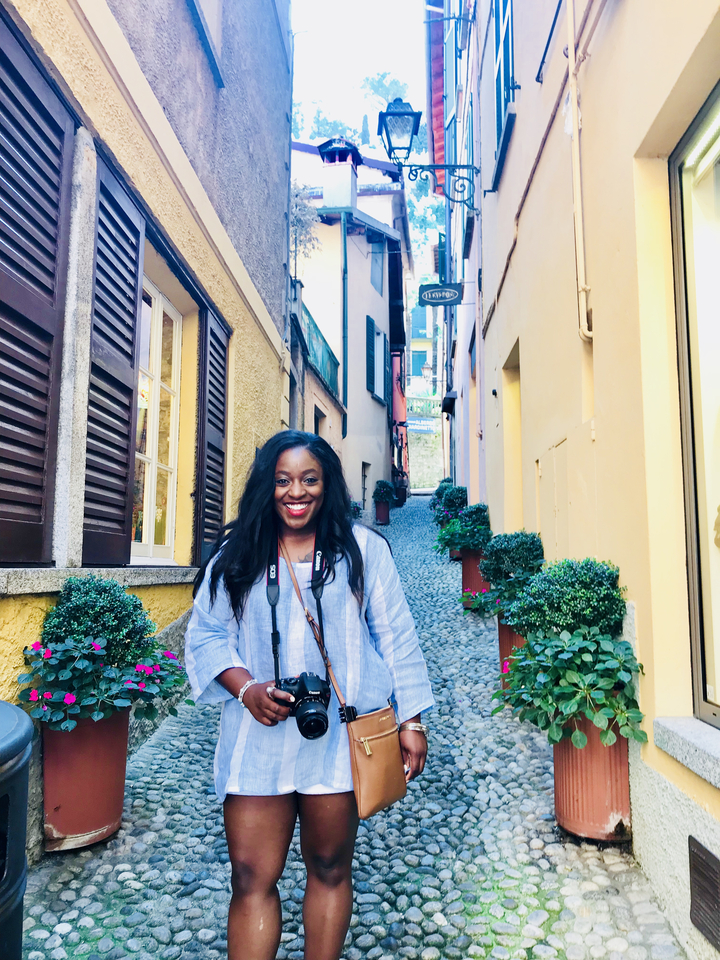 Personne souriante dans une rue pavée