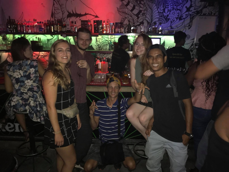 Groupe de personnes s'amusant dans un bar avec des lumières colorées