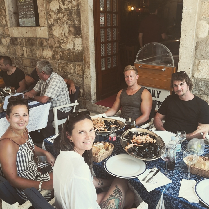 Repas de groupe dans un restaurant avec des plats de fruits de mer sur la table.