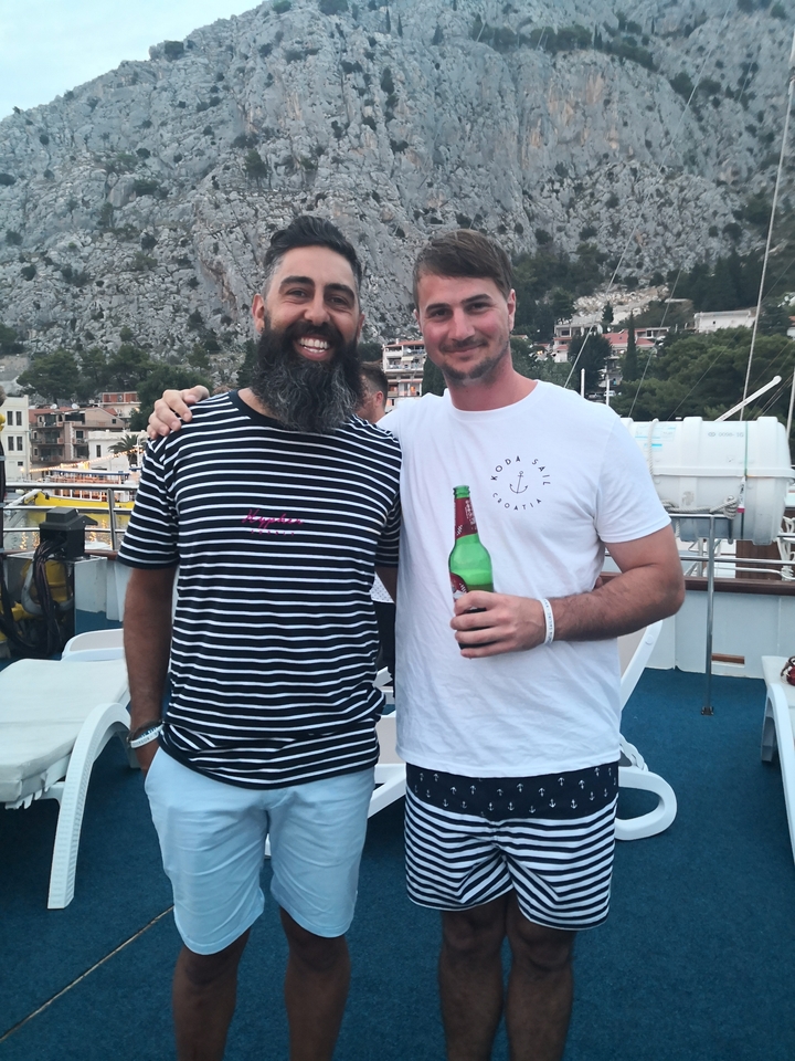 Deux hommes souriants qui posent ensemble sur un bateau.