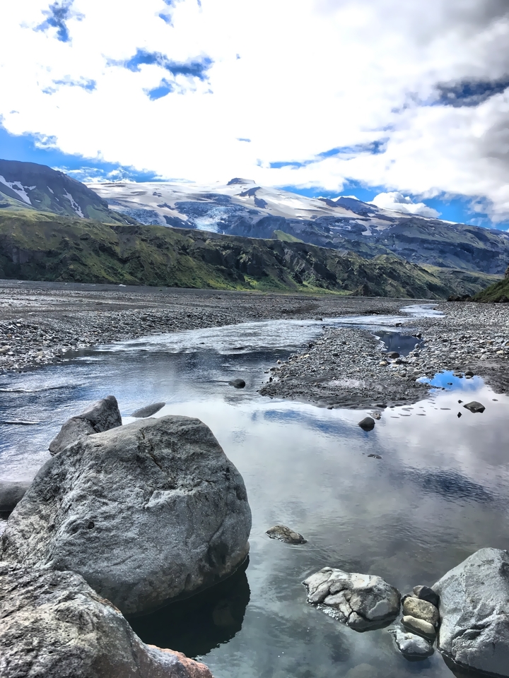 Paysage de montagne avec rivière et glacier.