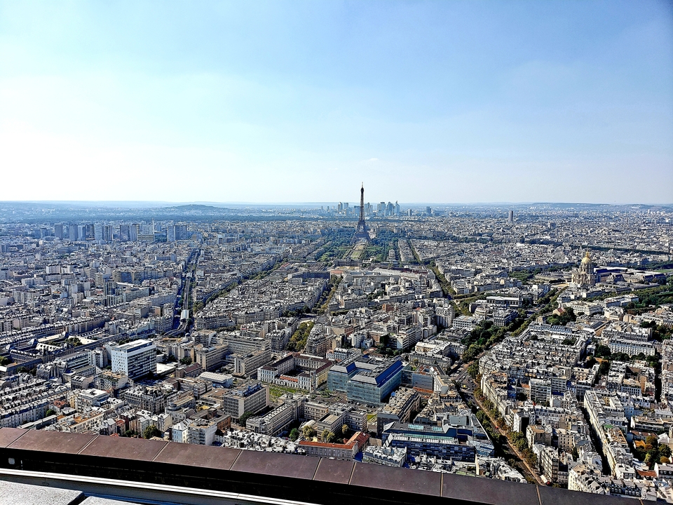 Vue panoramique du paysage urbain de Paris centrée sur la tour Eiffel.