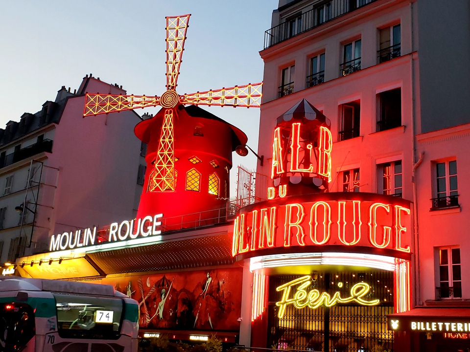 Iconique Moulin Rouge avec ses néons éclatants la nuit.