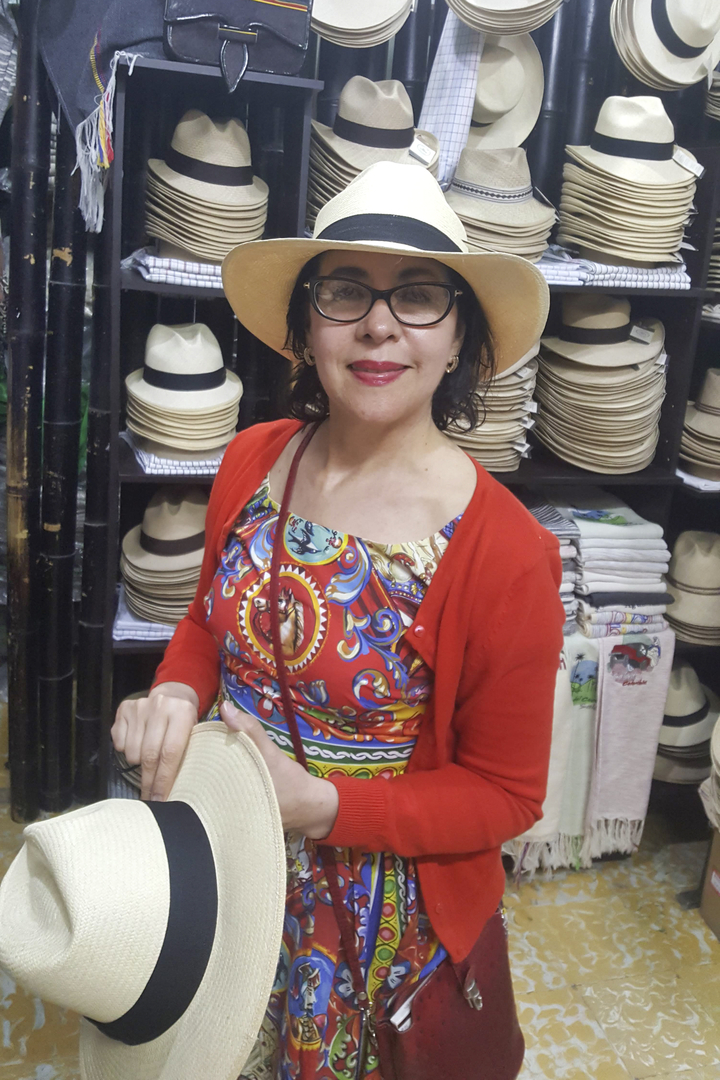 Une femme portant un chapeau dans un magasin avec beaucoup de chapeaux.