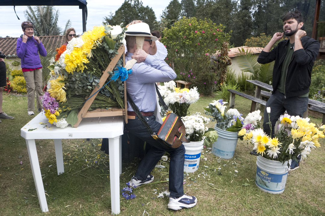 Une personne portant un grand arrangement floral sur le dos.