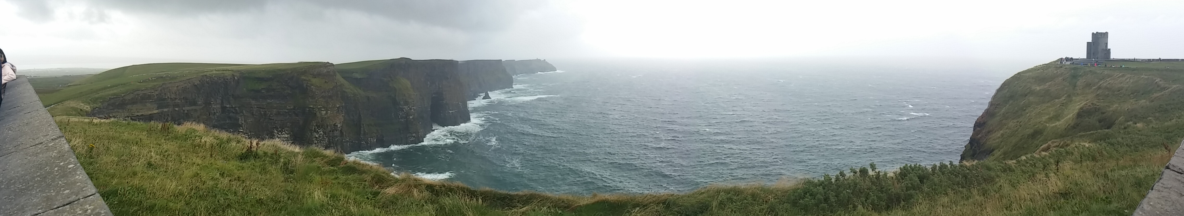 Une vue de falaises escarpées le long d'un littoral sous un ciel couvert.