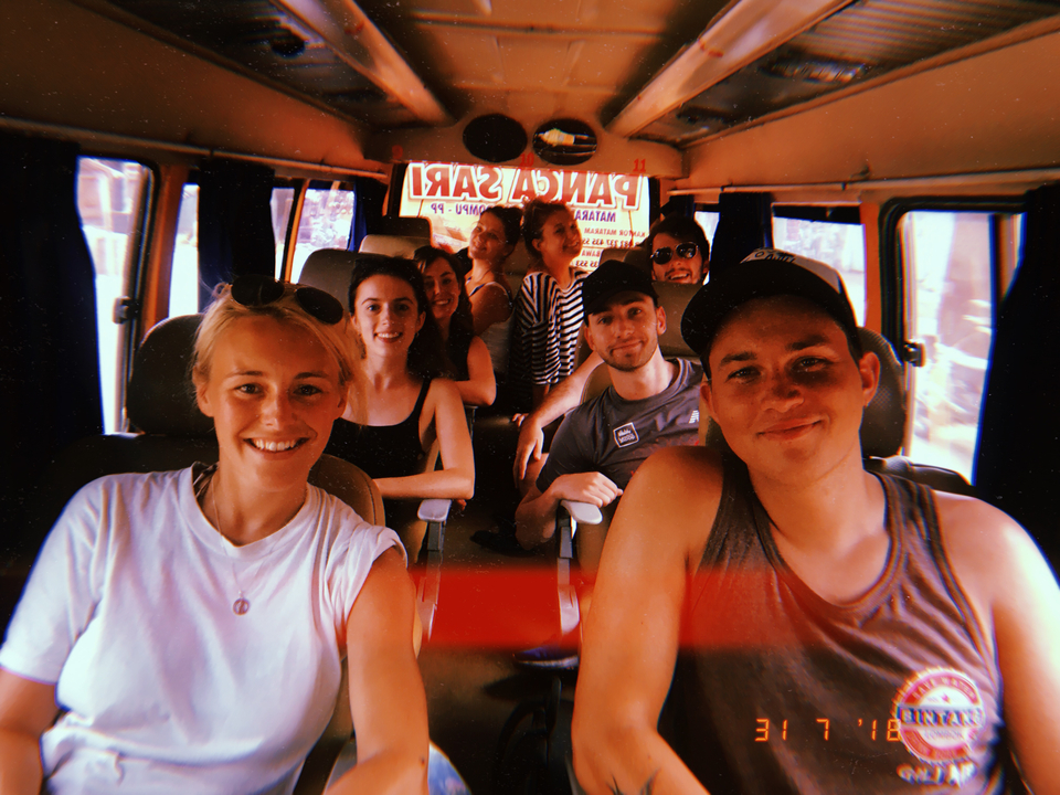 A group of friends inside a vehicle smiling at the camera.