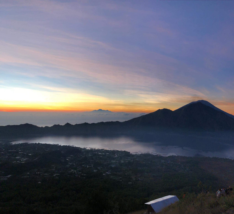 A sunrise over mountains and a calm lake, with vibrant colors.