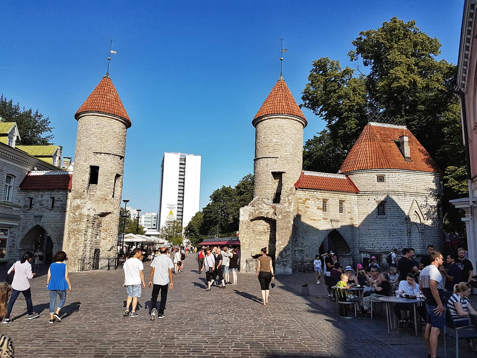 Scène de rue animée avec un vieux bâtiment en pierre.