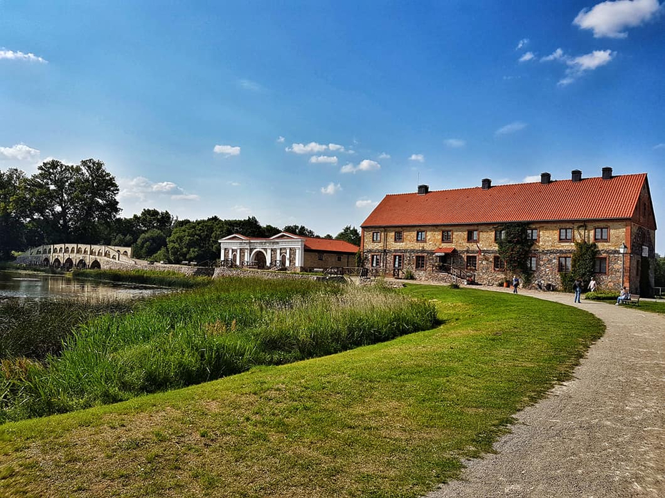 Bâtiments historiques au bord de la rivière sous un ciel ensoleillé.
