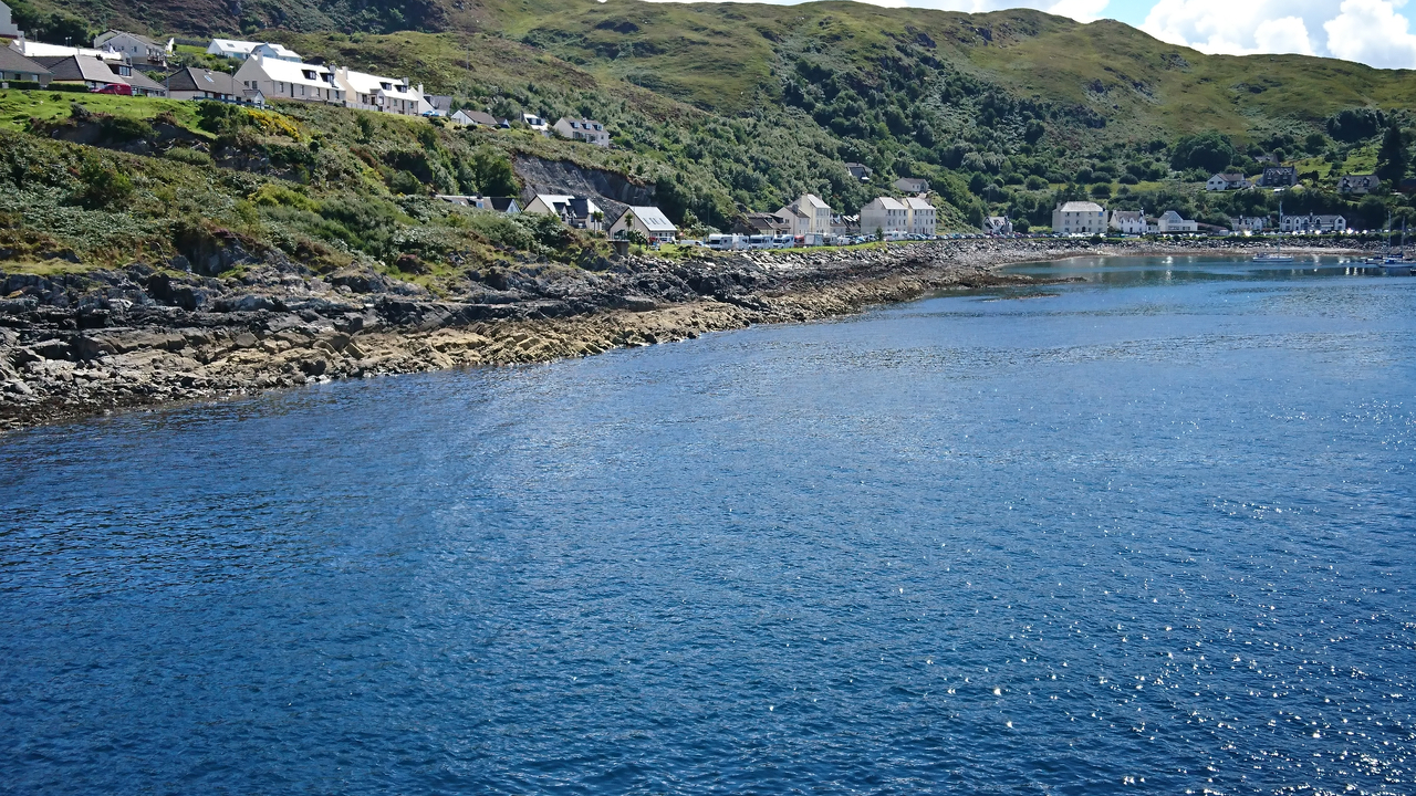 A coastal village with houses by a rocky shore.