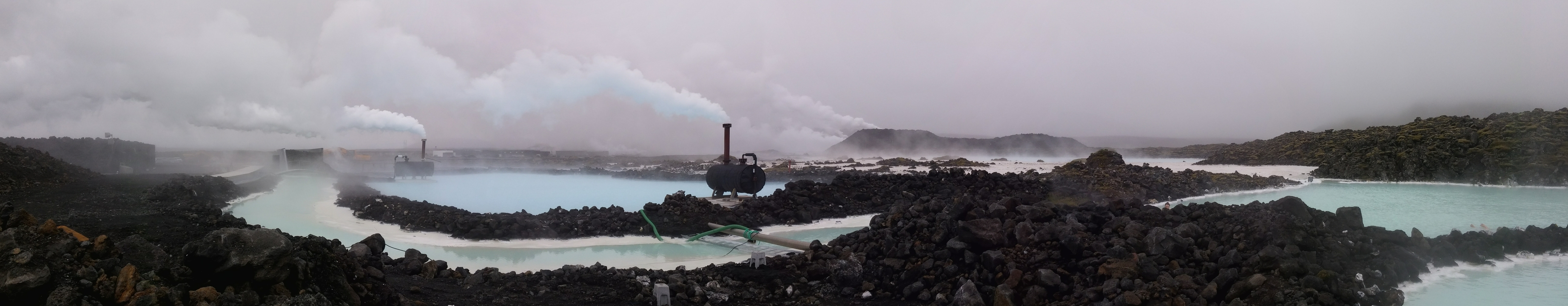Une zone géothermique avec des évents fumants et des bassins.