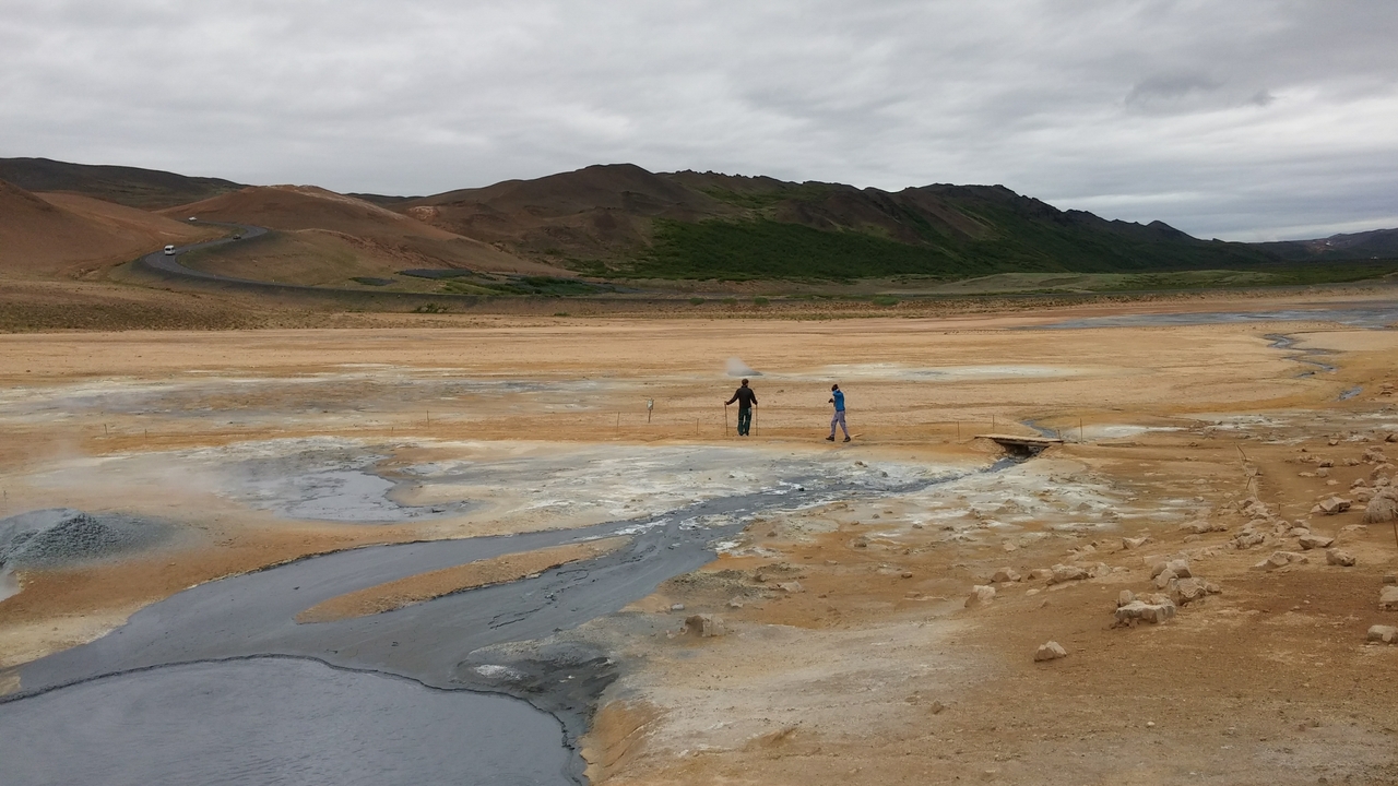 Un paysage aride avec des gens qui le traversent.