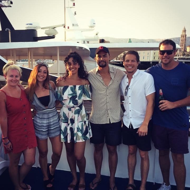 Un groupe d'amis posant sur un bateau.