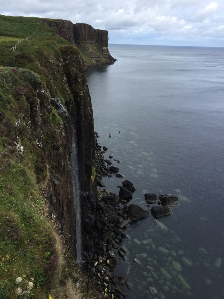 Vue depuis la falaise d'une cascade qui se jette dans l'océan.
