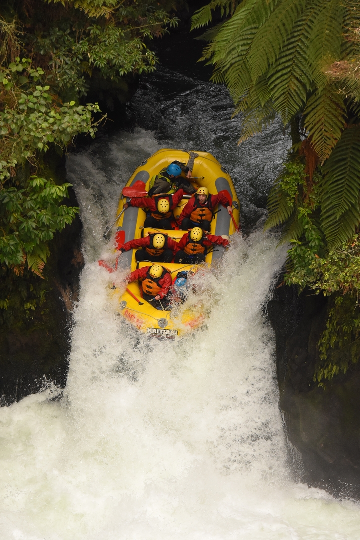 Groupe de personnes faisant du rafting en eaux vives sur des rapides.