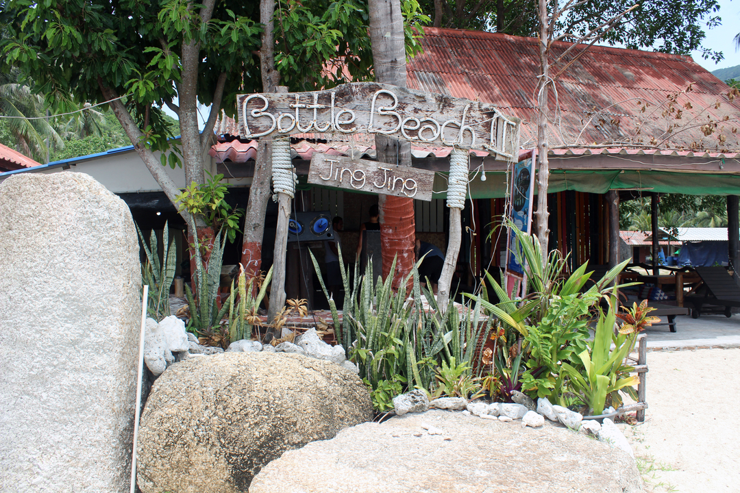 Entrée d'un lieu en bord de mer avec un panneau rustique.