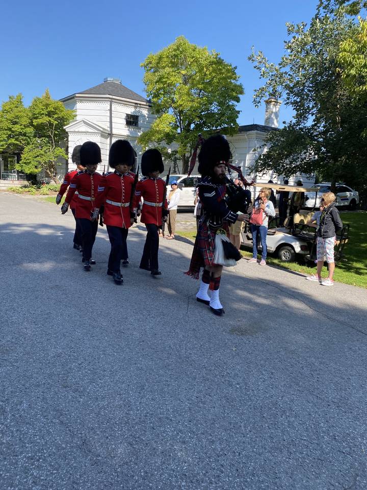 Défilé avec des personnes en vêtements traditionnels rouge et noir jouant de la cornemuse.