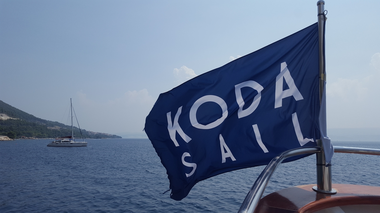 Gros plan d'un drapeau avec le texte 'KODA SAIL' sur un bateau.