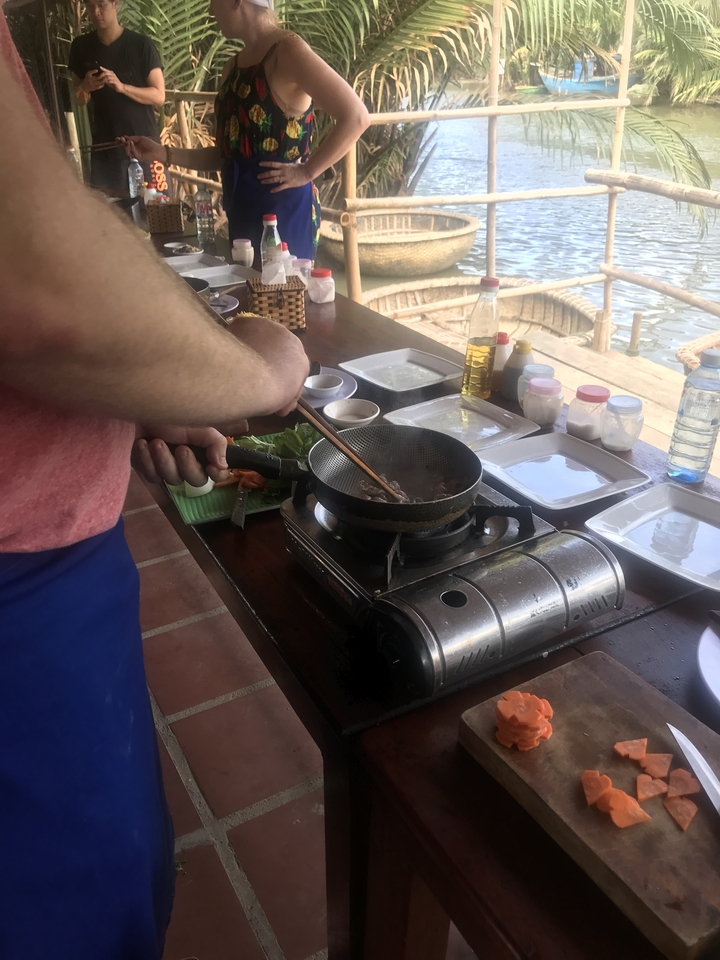 Personne cuisinant sur une cuisinière à gaz près d'un point d'eau.