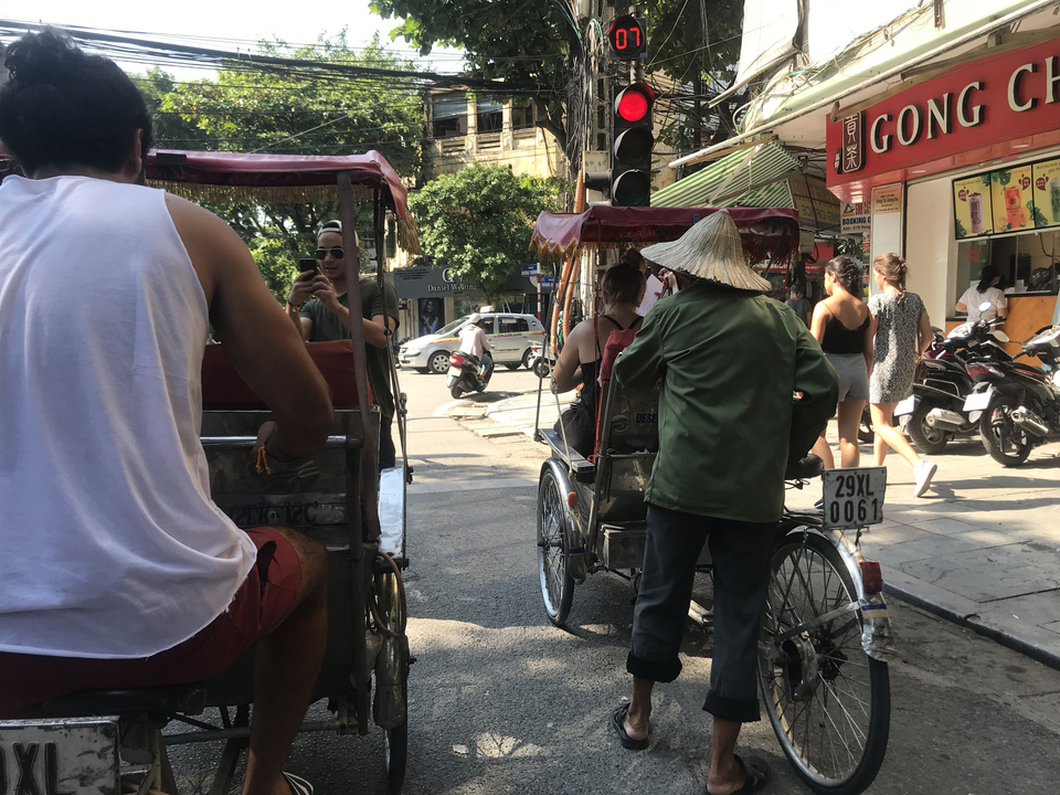 Groupe de personnes sur des cyclo-pousse dans une rue de la ville.