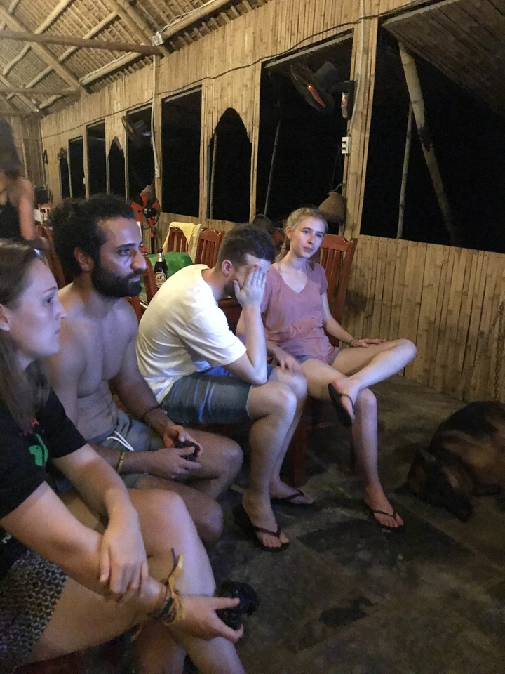Des gens assis dans une pièce faiblement éclairée.