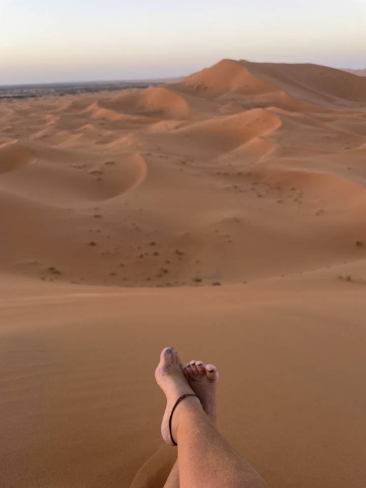 Gedrehtes Bild von Füßen über einer weiten Wüstenlandschaft.