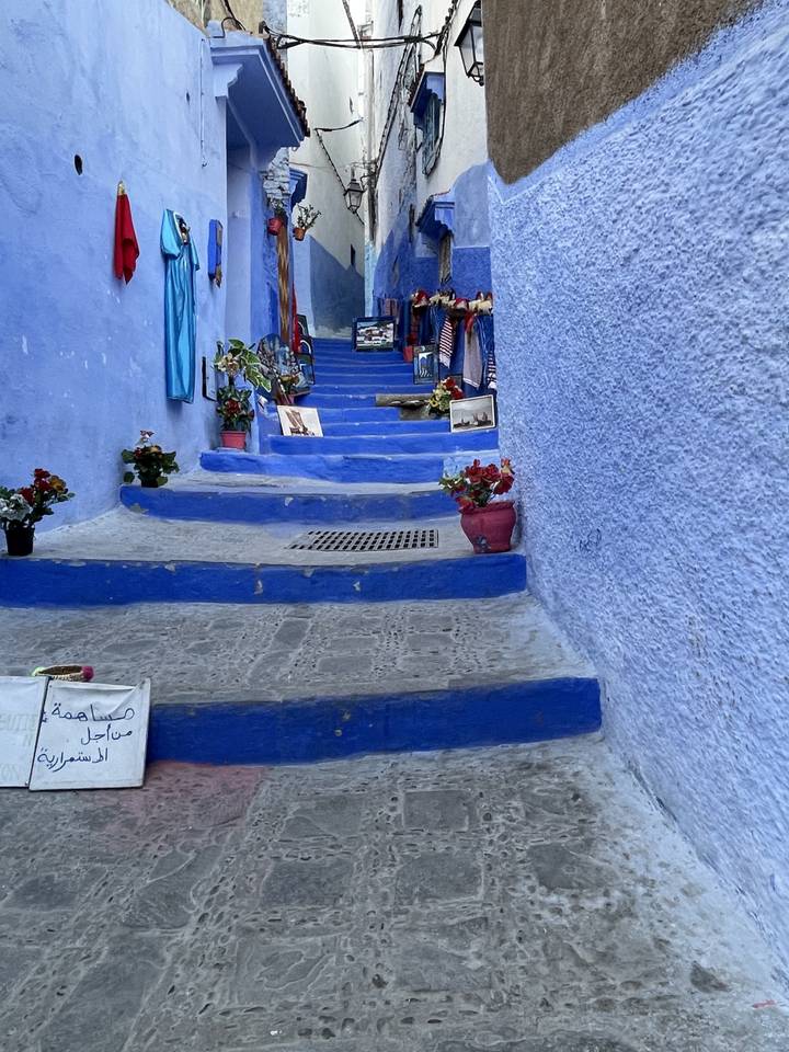 Gedrehtes Bild einer blau gestrichenen schmalen Gasse mit Steinstufen.