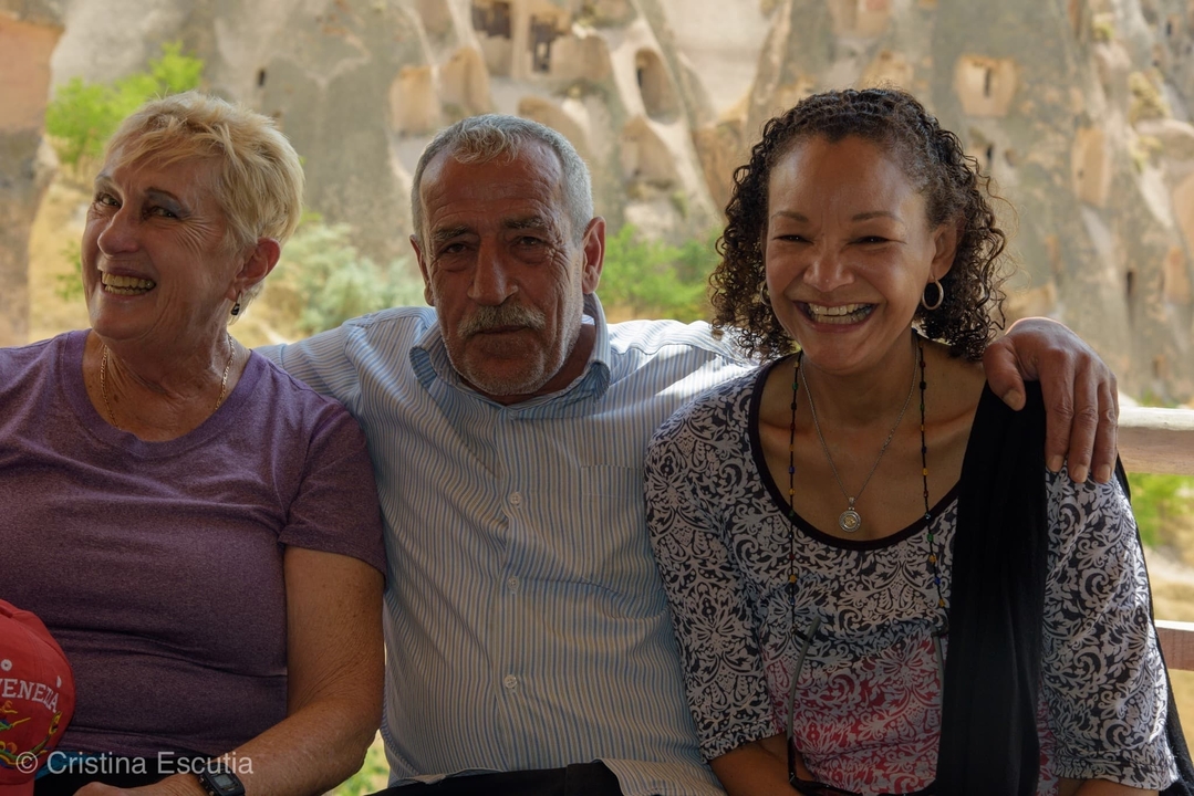 Trois personnes souriantes avec les bras autour les unes des autres.