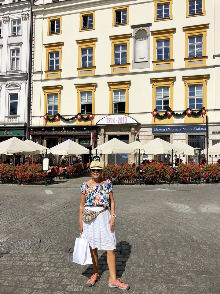 Femme debout devant un bâtiment avec des décorations festives.