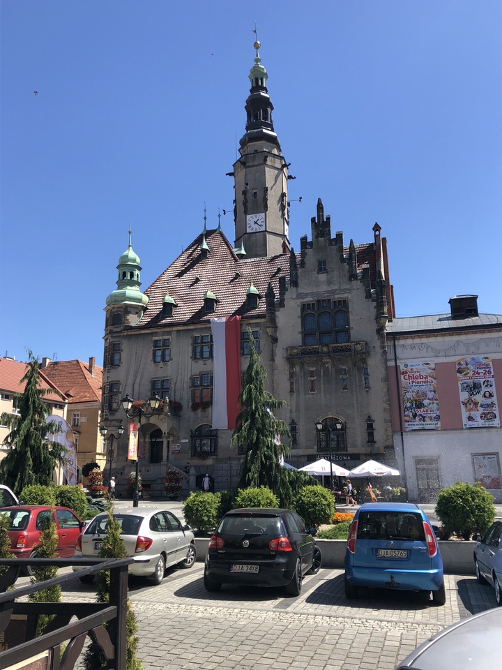 Bâtiment historique avec une tour d'horloge et des drapeaux devant.