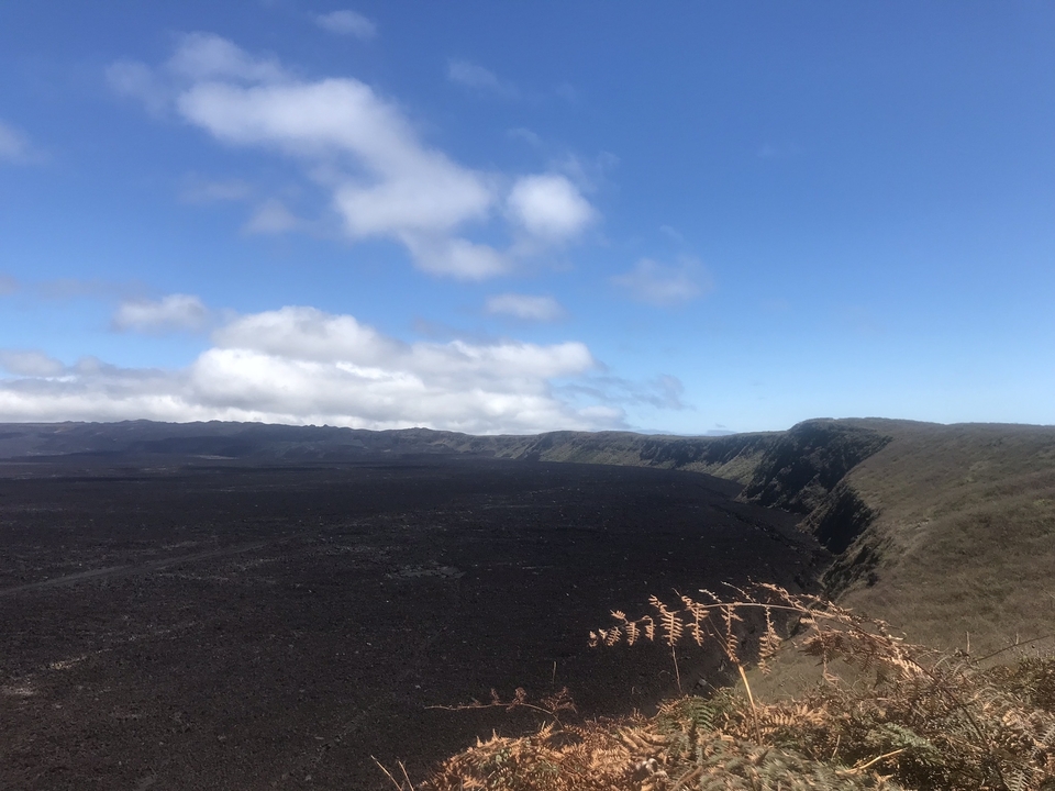 Vue large d'un paysage volcanique sous un ciel bleu.
