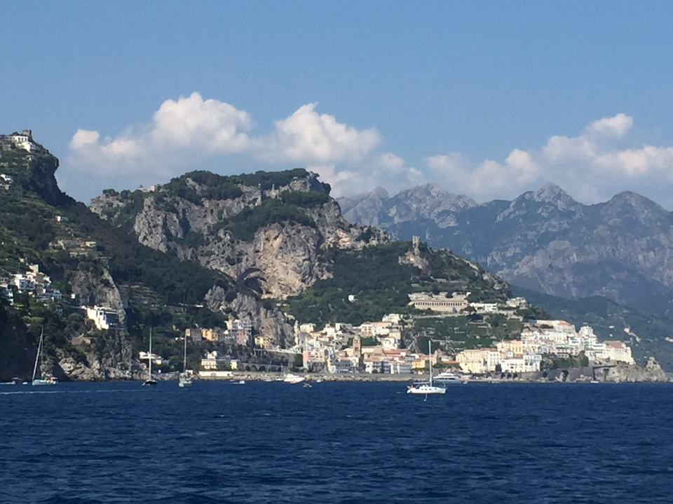 Ville côtière au bord de la mer avec des montagnes en arrière-plan.
