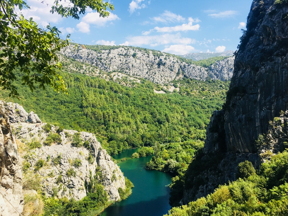 Une vue d'un terrain montagneux accidenté avec une rivière en contrebas.