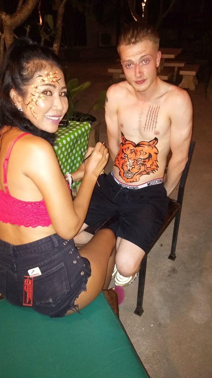 Séance de body painting avec un accent sur un motif de tigre.