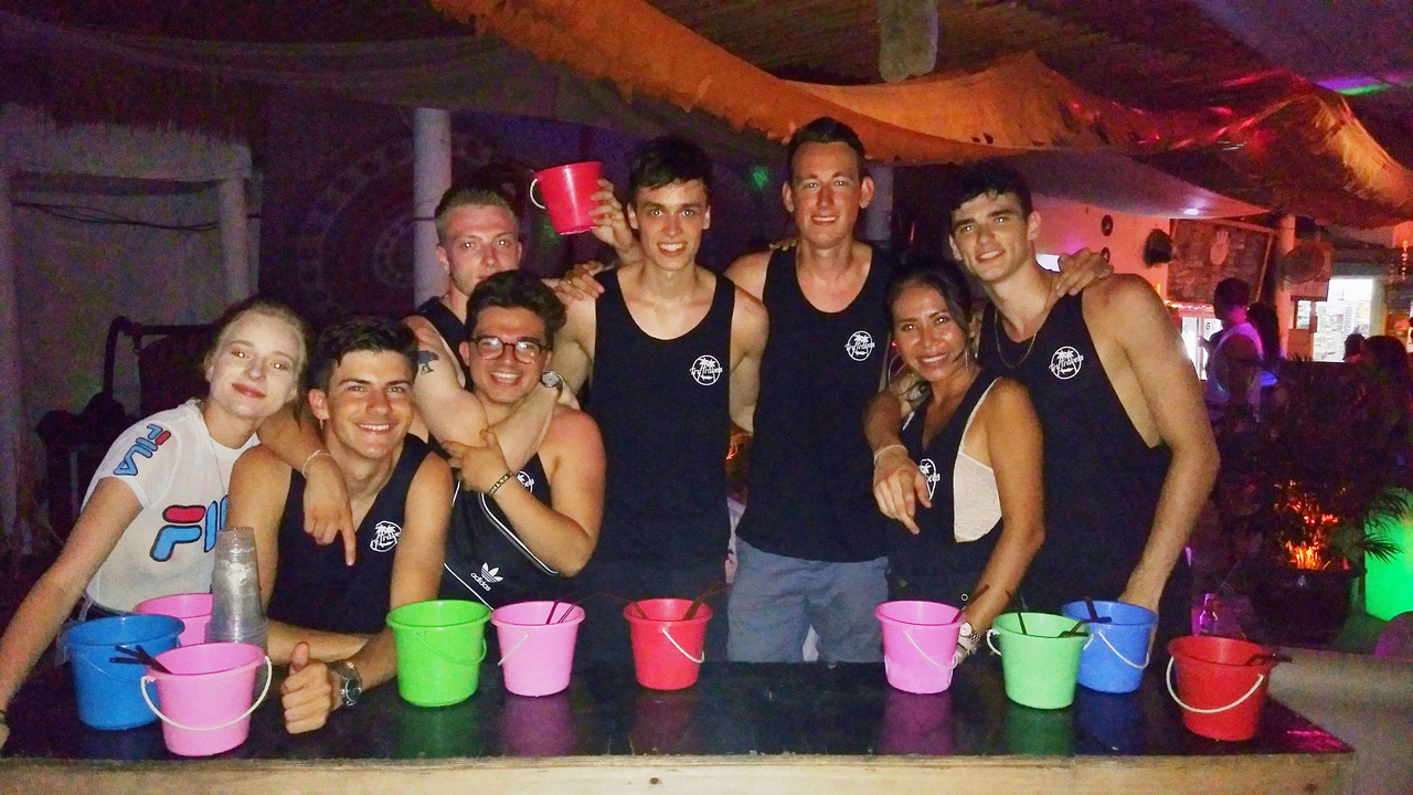 Gruppe von Personen, die hinter einer Bar mit Getränken steht.