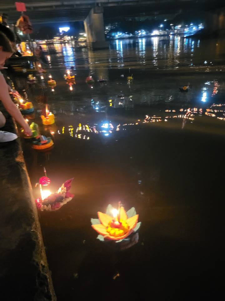 Floating lanterns on a river at night.