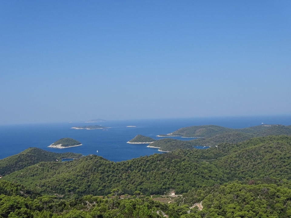 Vue aérienne d'îles verdoyantes dans un océan bleu entourées d'un ciel dégagé.