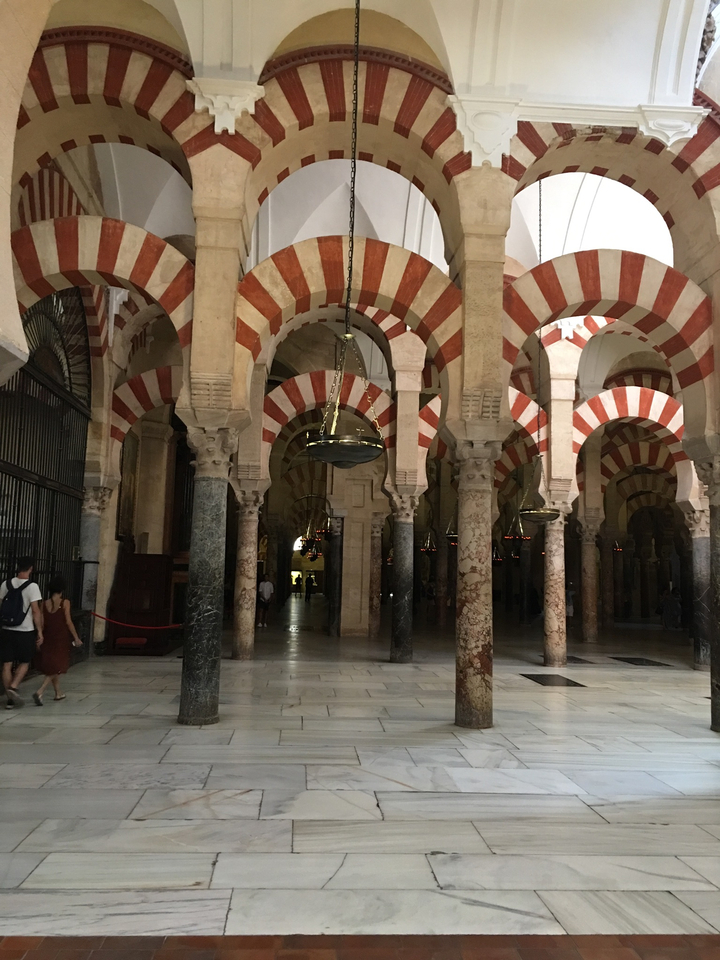 Intérieur d'une mosquée avec des arcs et des colonnes.