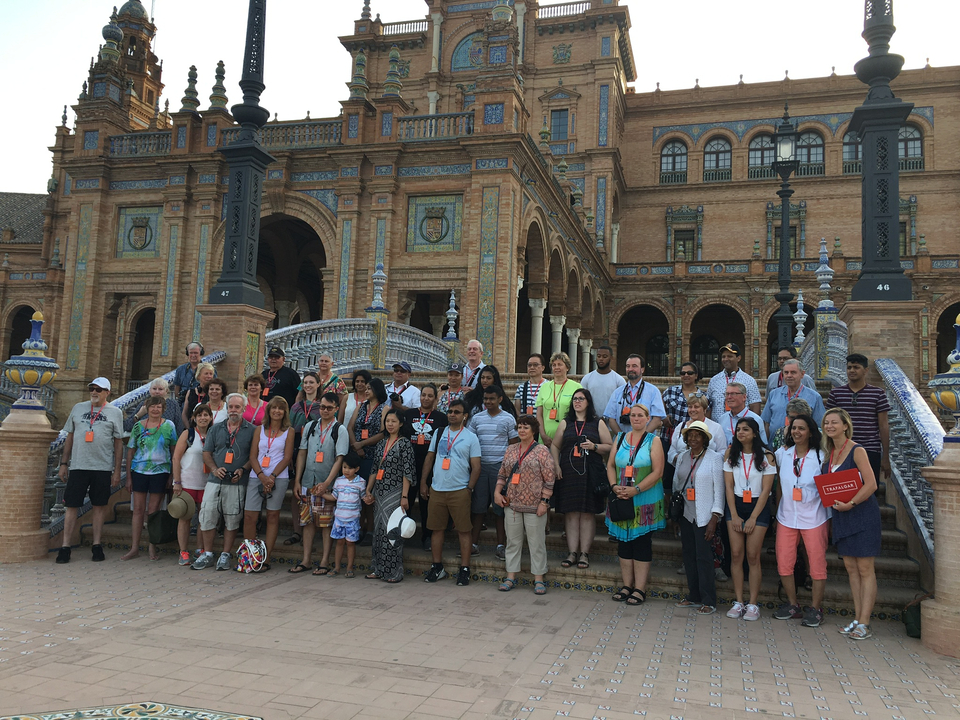 Grand groupe de personnes debout devant un bâtiment historique.