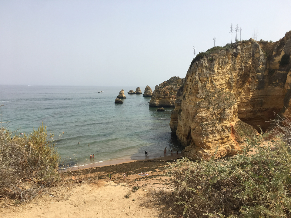 Côte rocheuse avec océan et baigneurs.