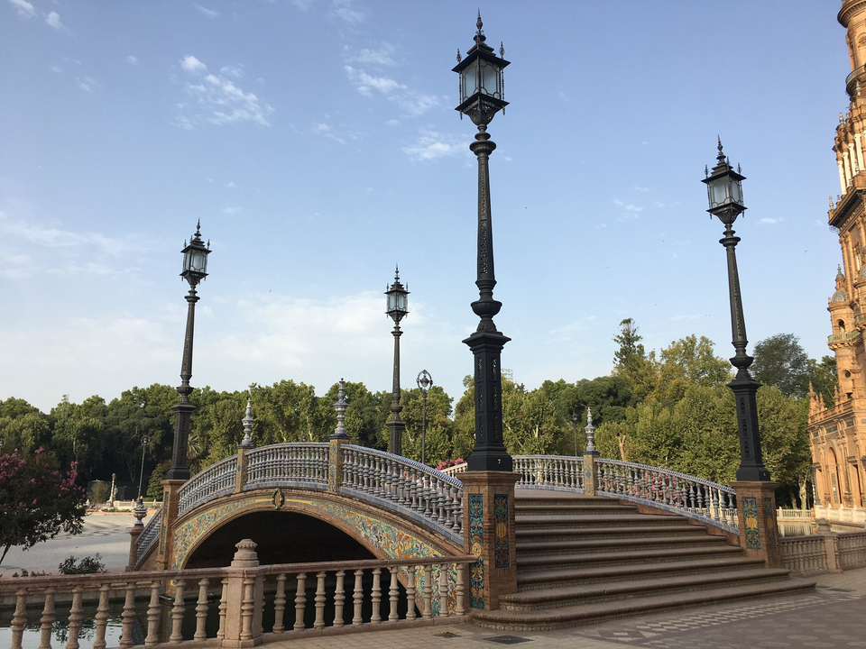 Pont avec lampadaires décoratifs sur une place historique.