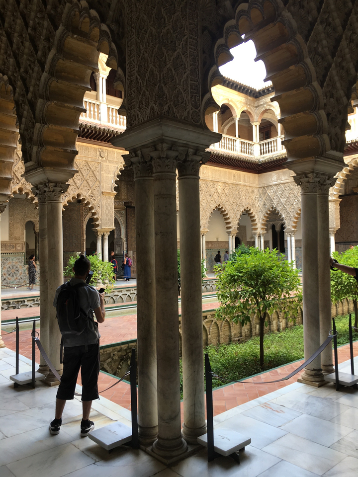 Cour intérieure avec arches et carrelage complexe.