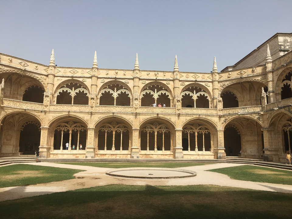 Bâtiment historique orné avec des personnes dans la cour.