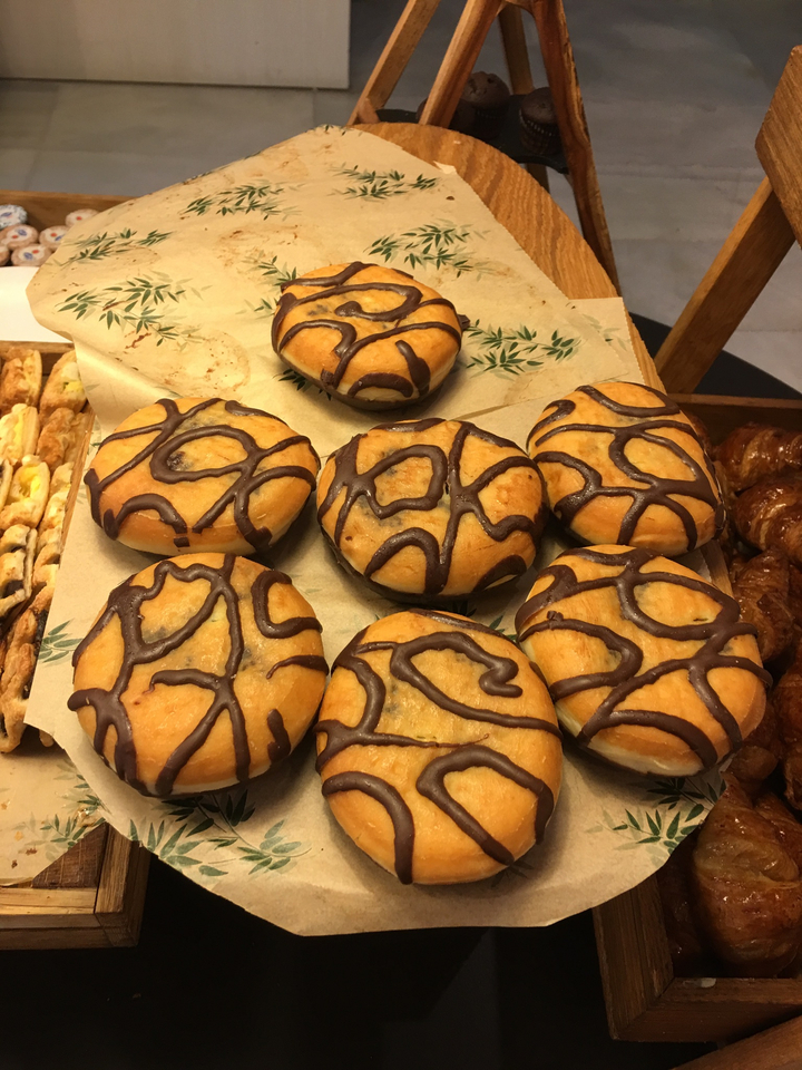 Pâtisseries nappées de chocolat exposées dans une boulangerie.