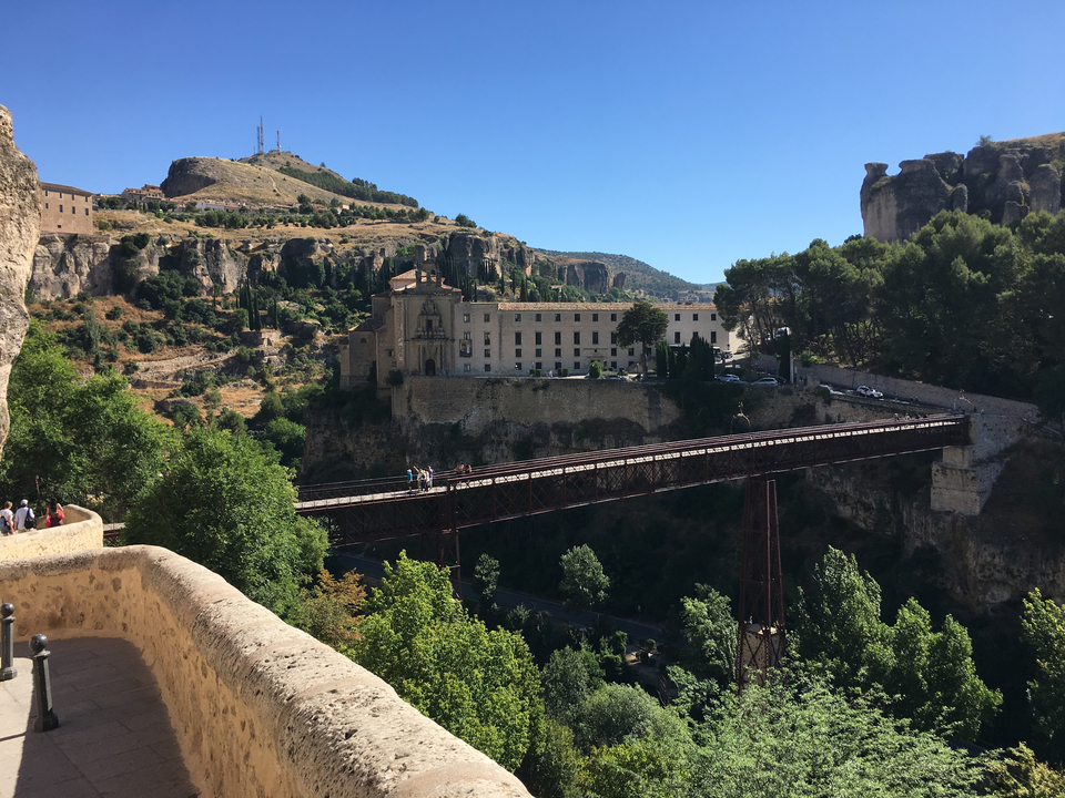 Vue panoramique d'un pont enjambant une gorge avec un paysage vallonné.