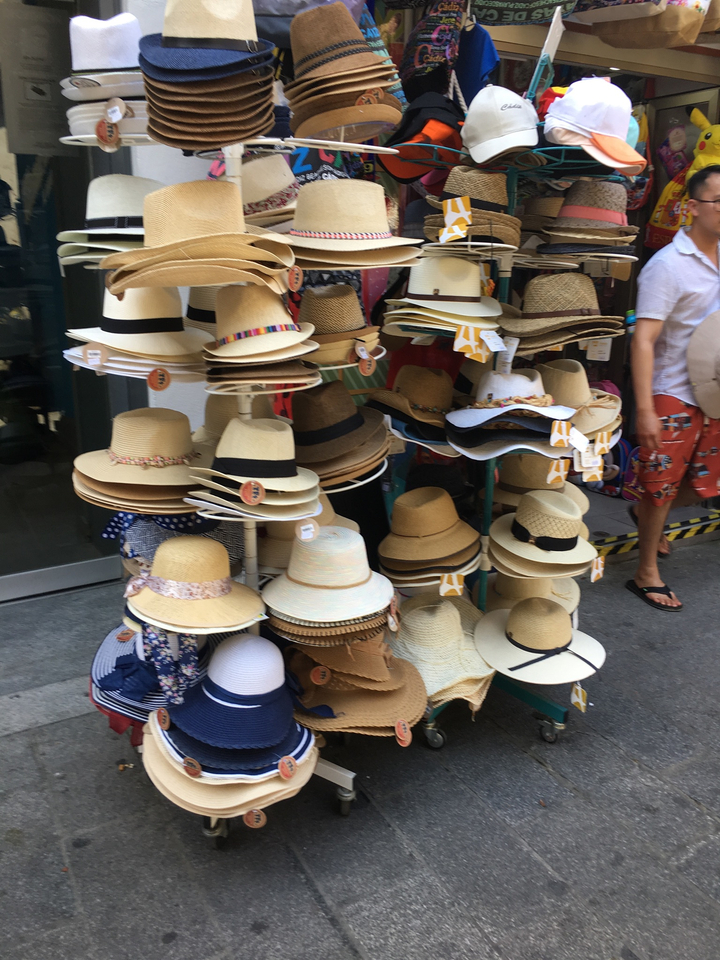 Présentation de divers chapeaux sur un présentoir.