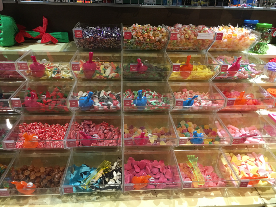 Divers bonbons colorés exposés dans un magasin.