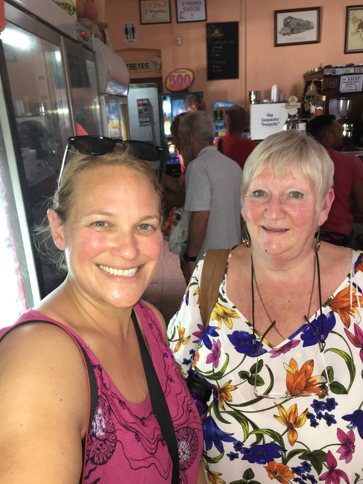 Deux femmes souriantes prenant un selfie à l'intérieur.