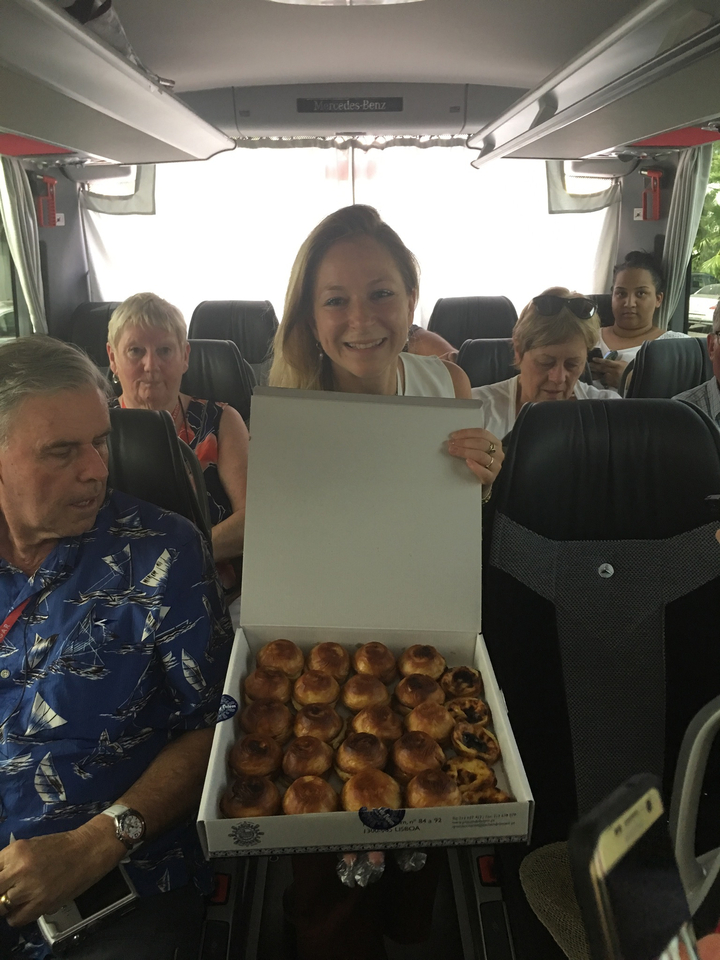 Des gens dans un bus avec une femme tenant une boîte de pâtisseries.